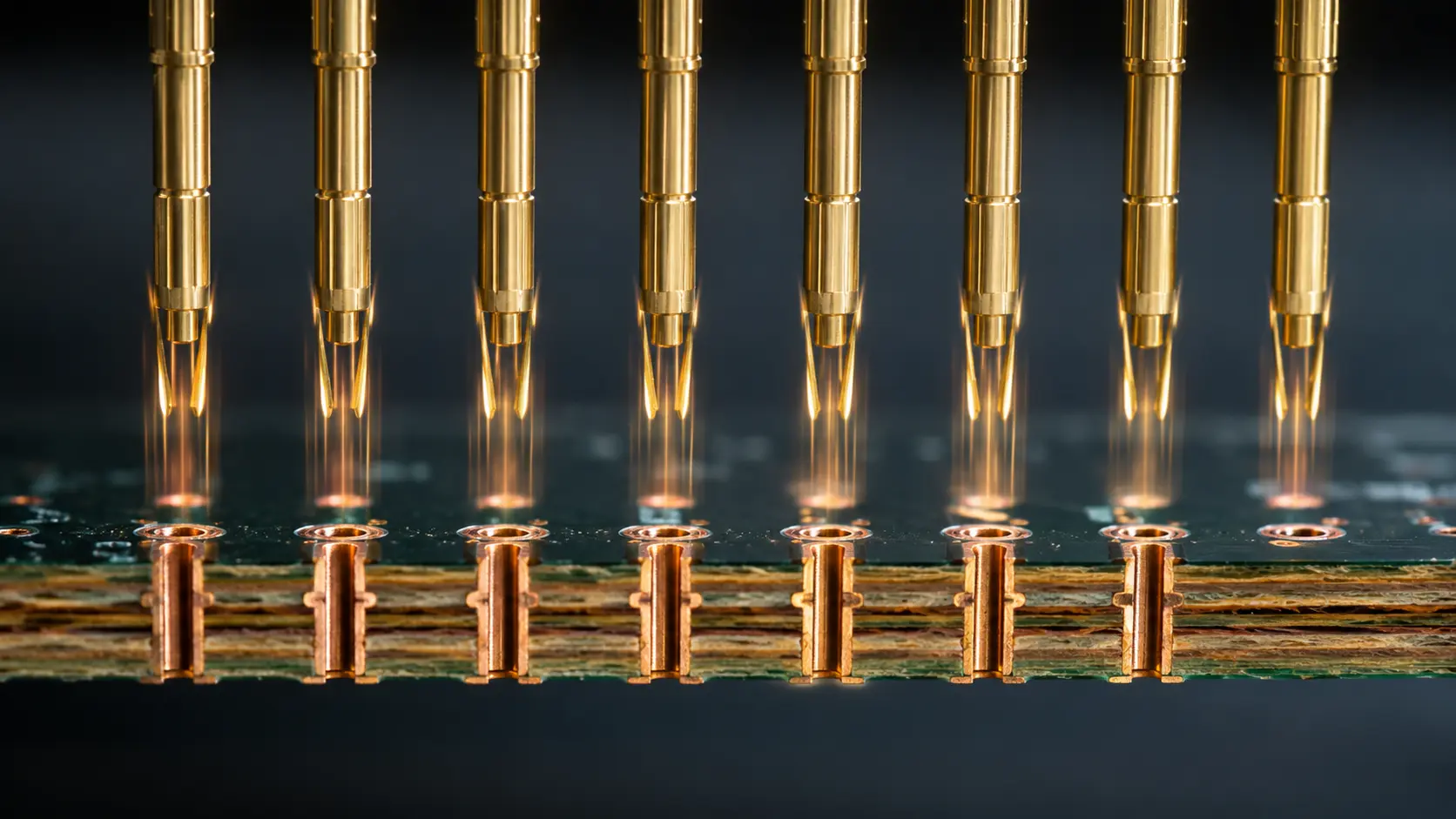 Press-fit connector pins aligned above controlled plated PCB holes with visible annular rings