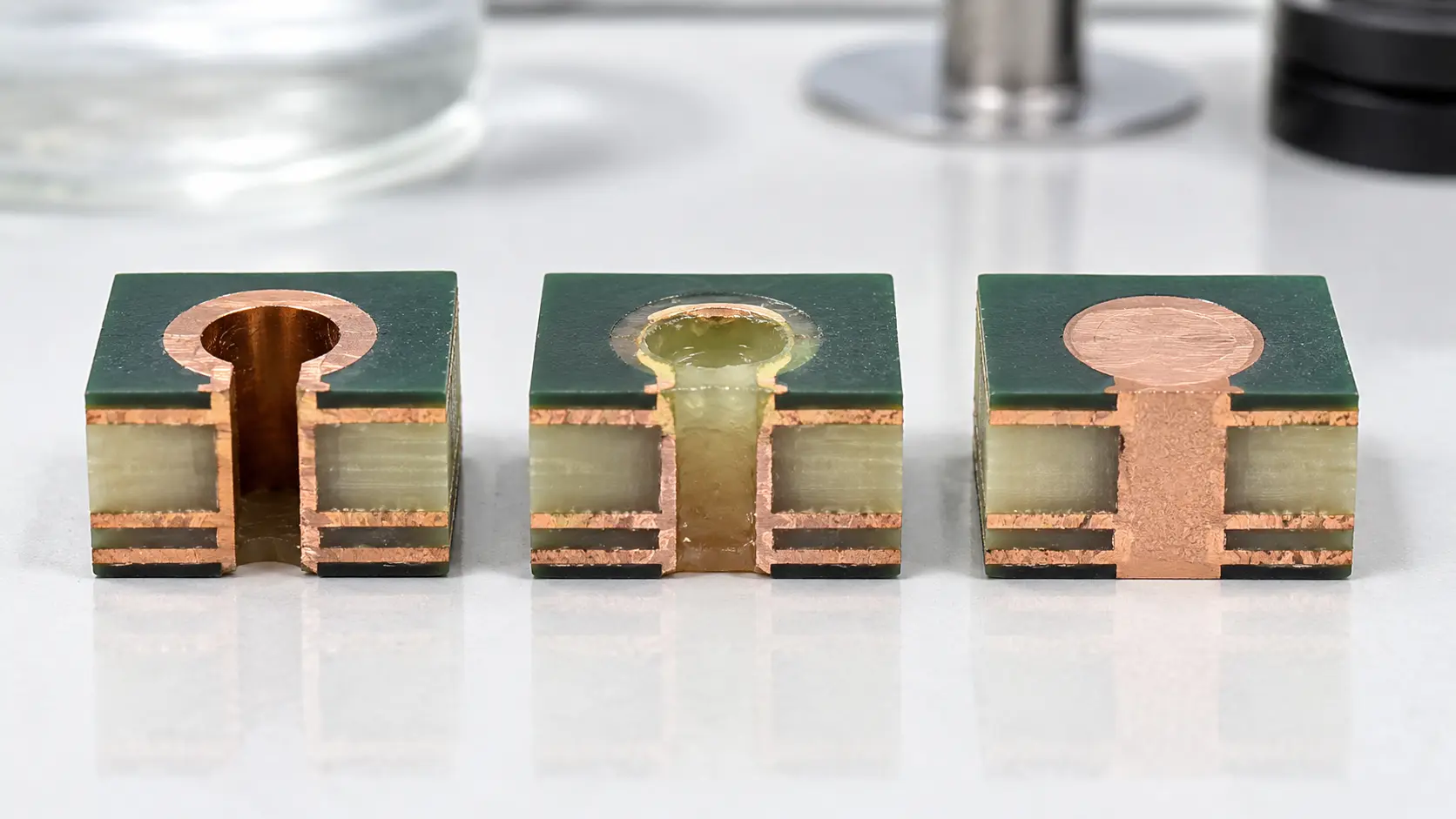Comparison of an open via in pad, a depressed protected via, and a filled planarized copper-capped via